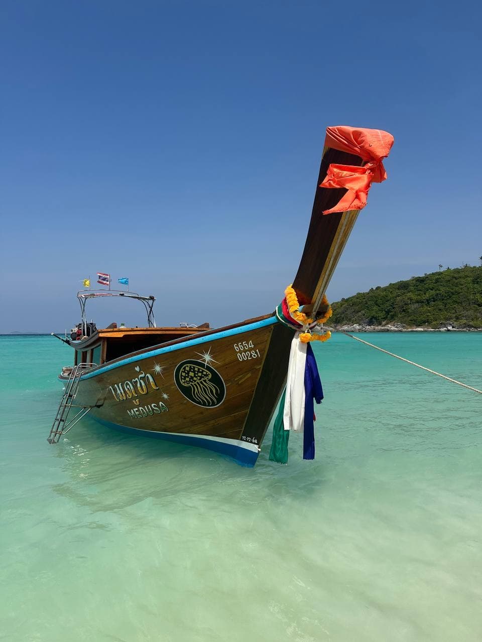 Front view of Medusa longtail boat in shallow tropical water