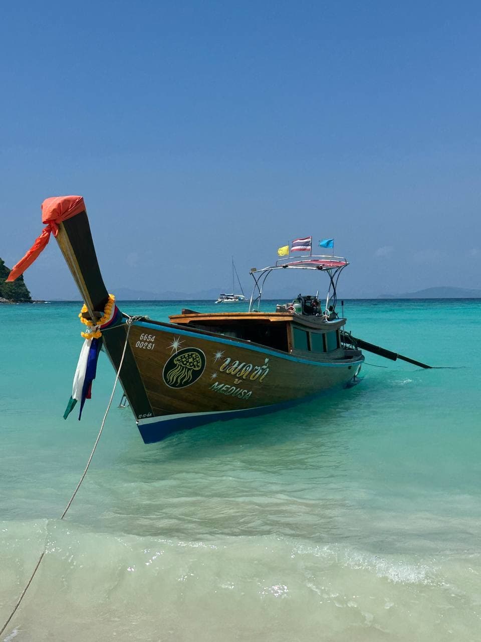 Premium longtail boat waiting in shallow clear water