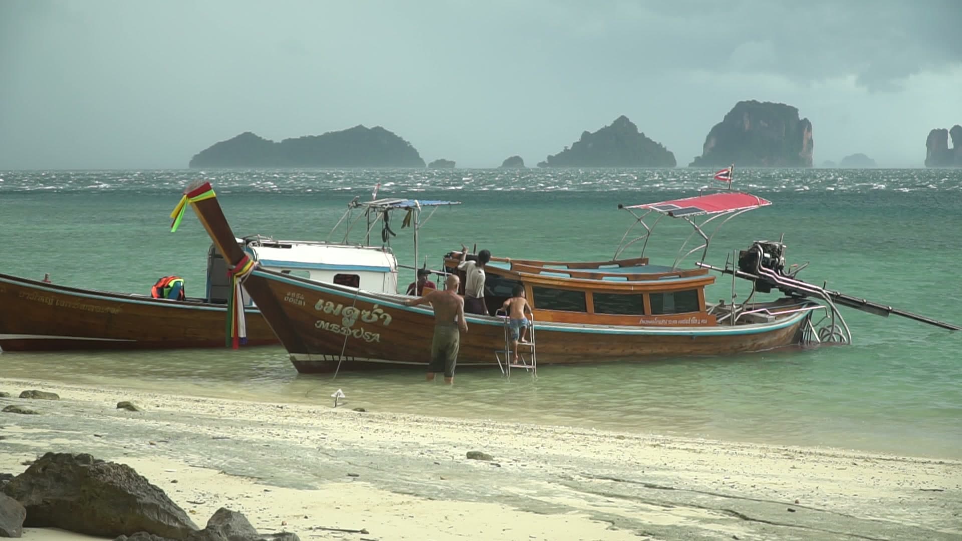 Longtail boat with limestone islands in Phang Nga Bay
