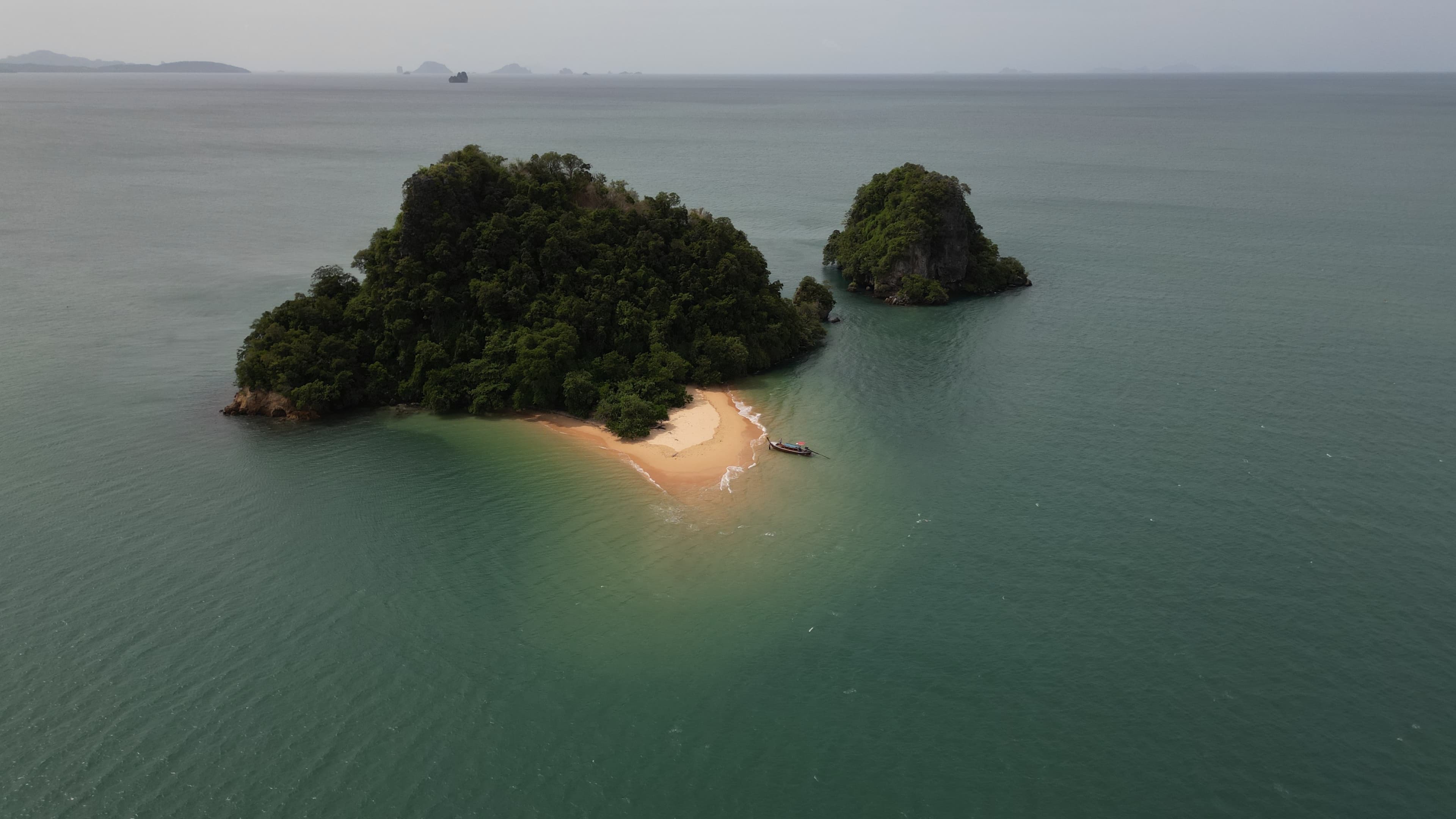 Small green island and calm sea from above