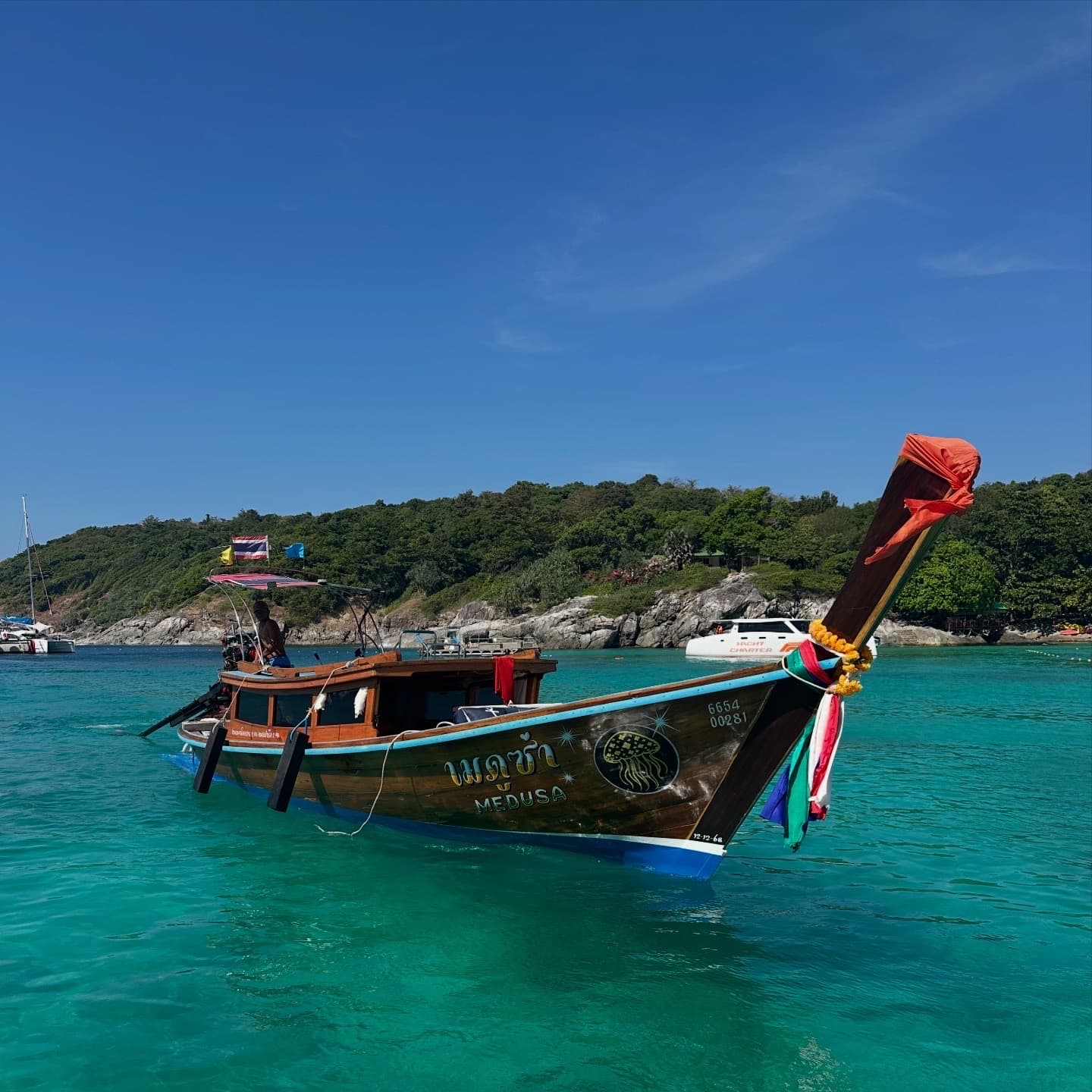 Private longtail boat on tropical clear water